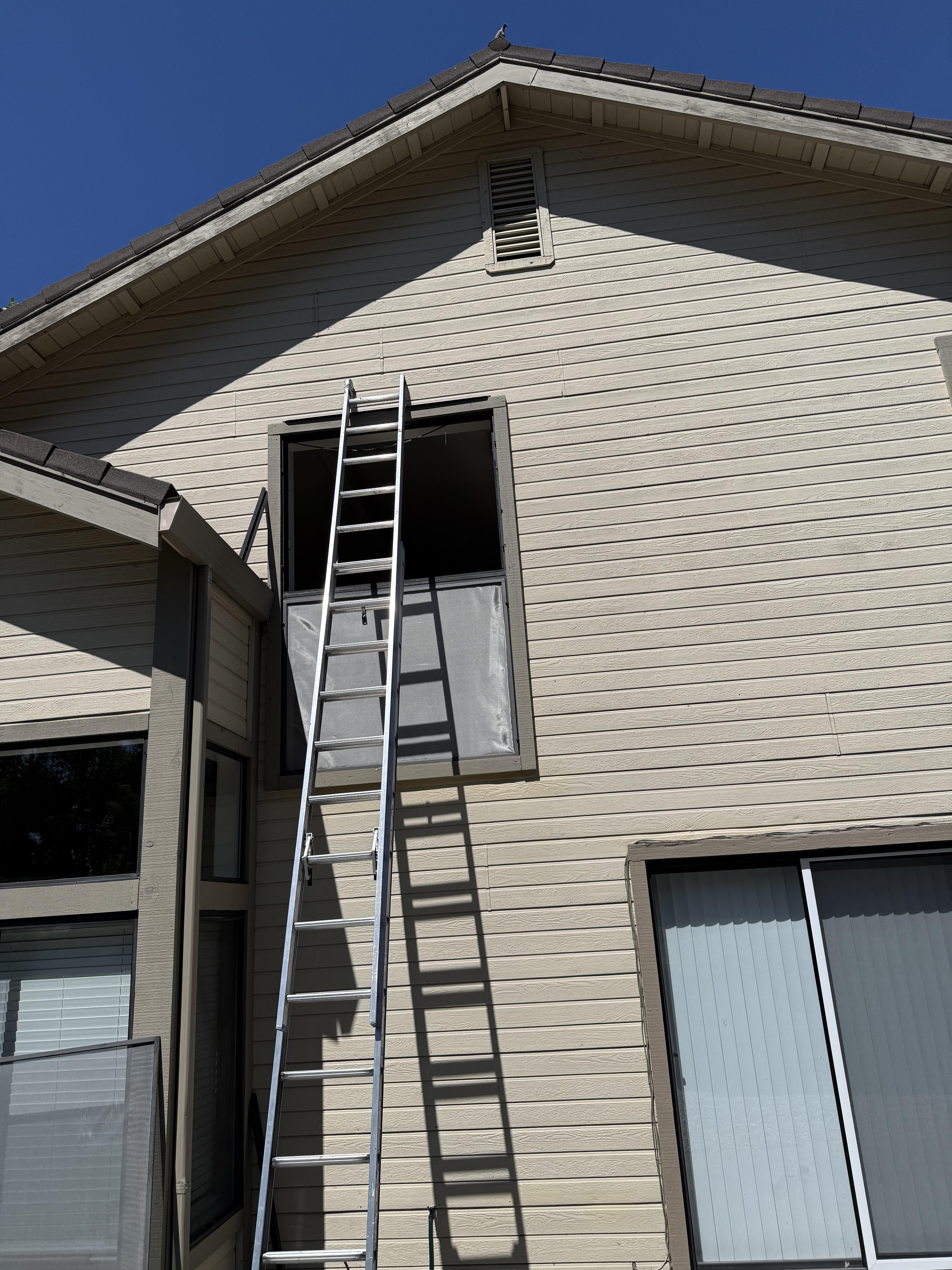 Ladder set up to reach a second-story window