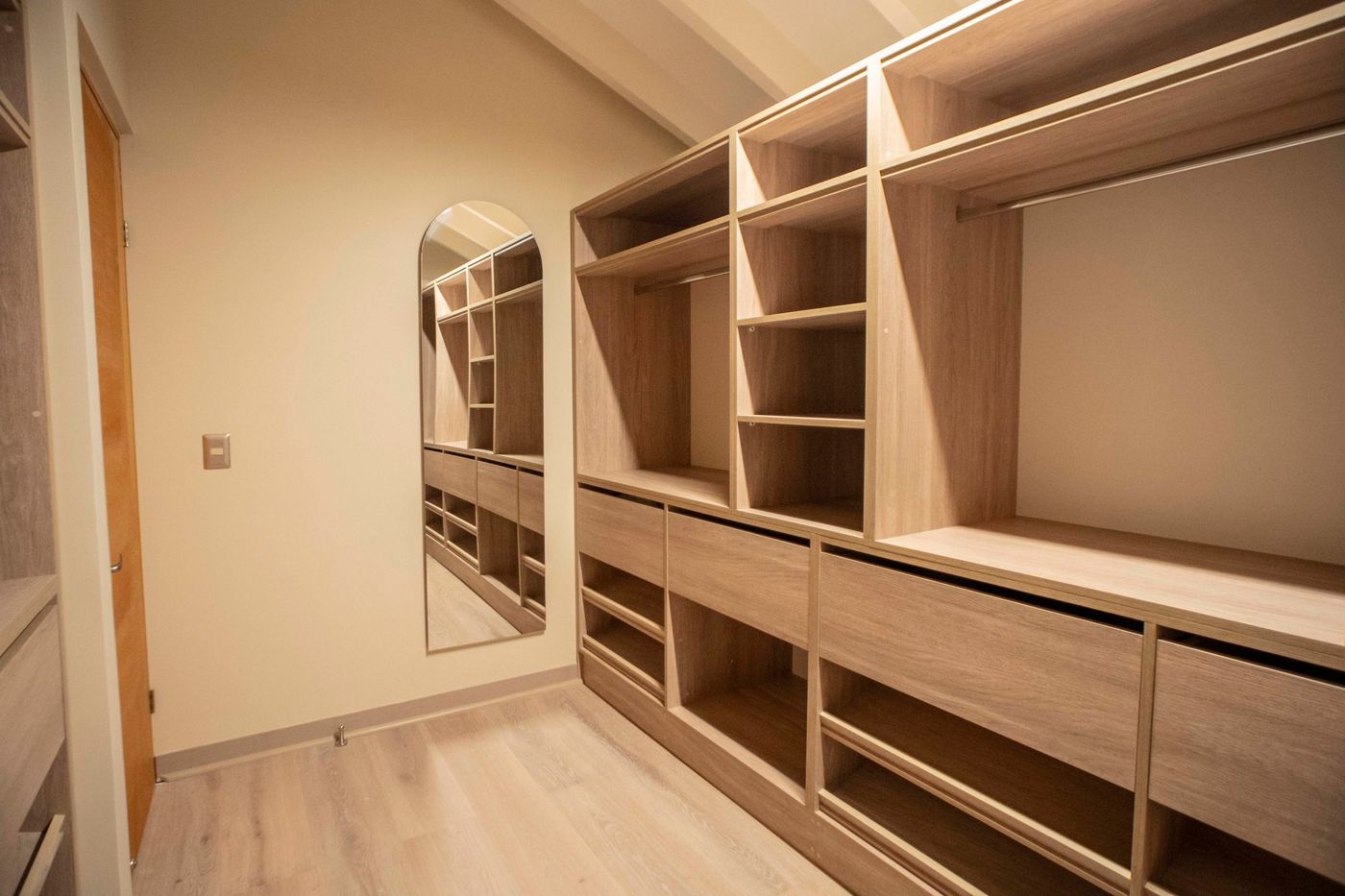 Walk-in closet de Casa Arrayán con muebles de madera y espejo