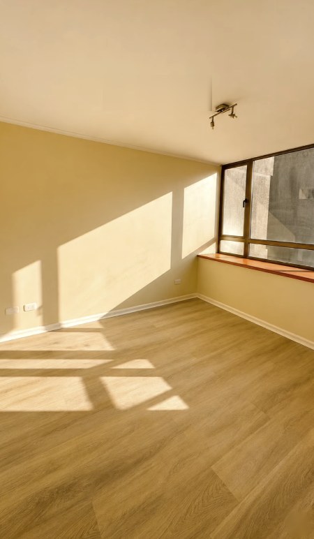 Dormitorio del departamento en Las Condes con piso nuevo tipo madera y muros pintados
