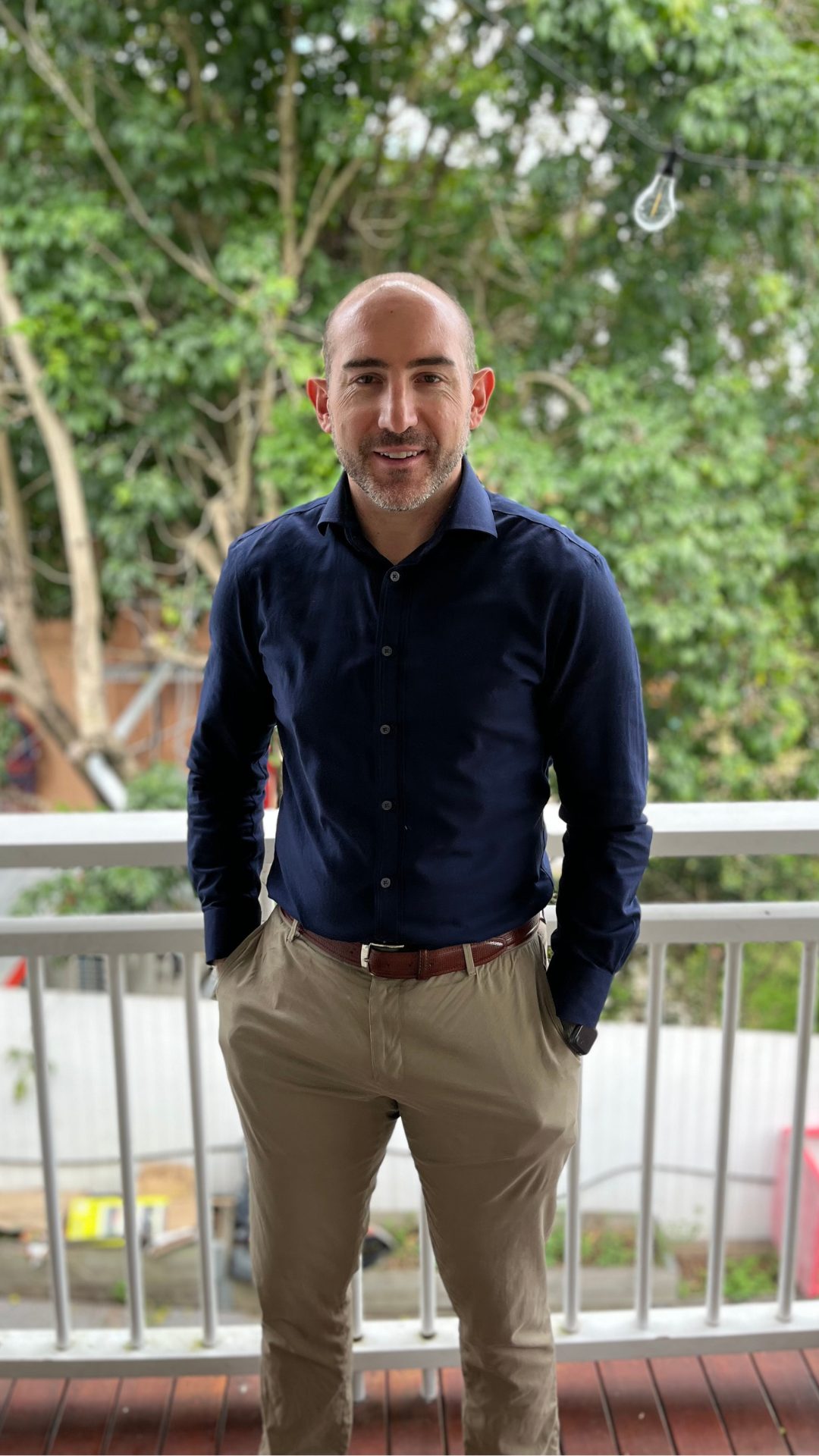 Barry Morris standing on a timber deck in a navy shirt with trees behind him