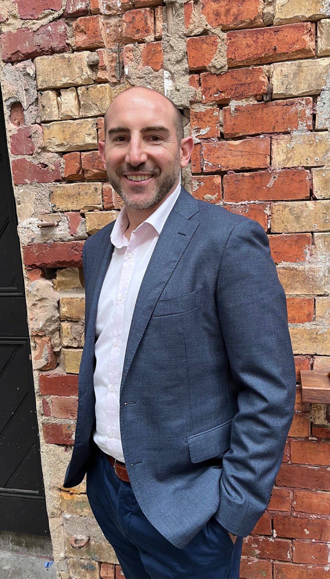 Barry Morris standing against a brick wall