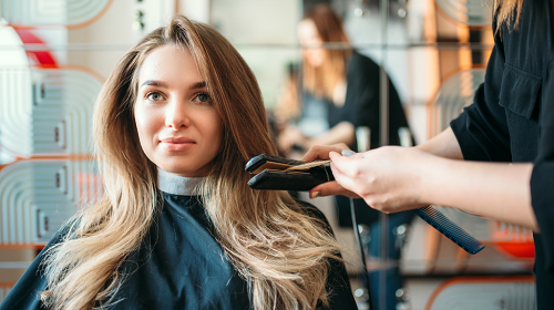 Customer at a salon getting her hair done by a stylist
