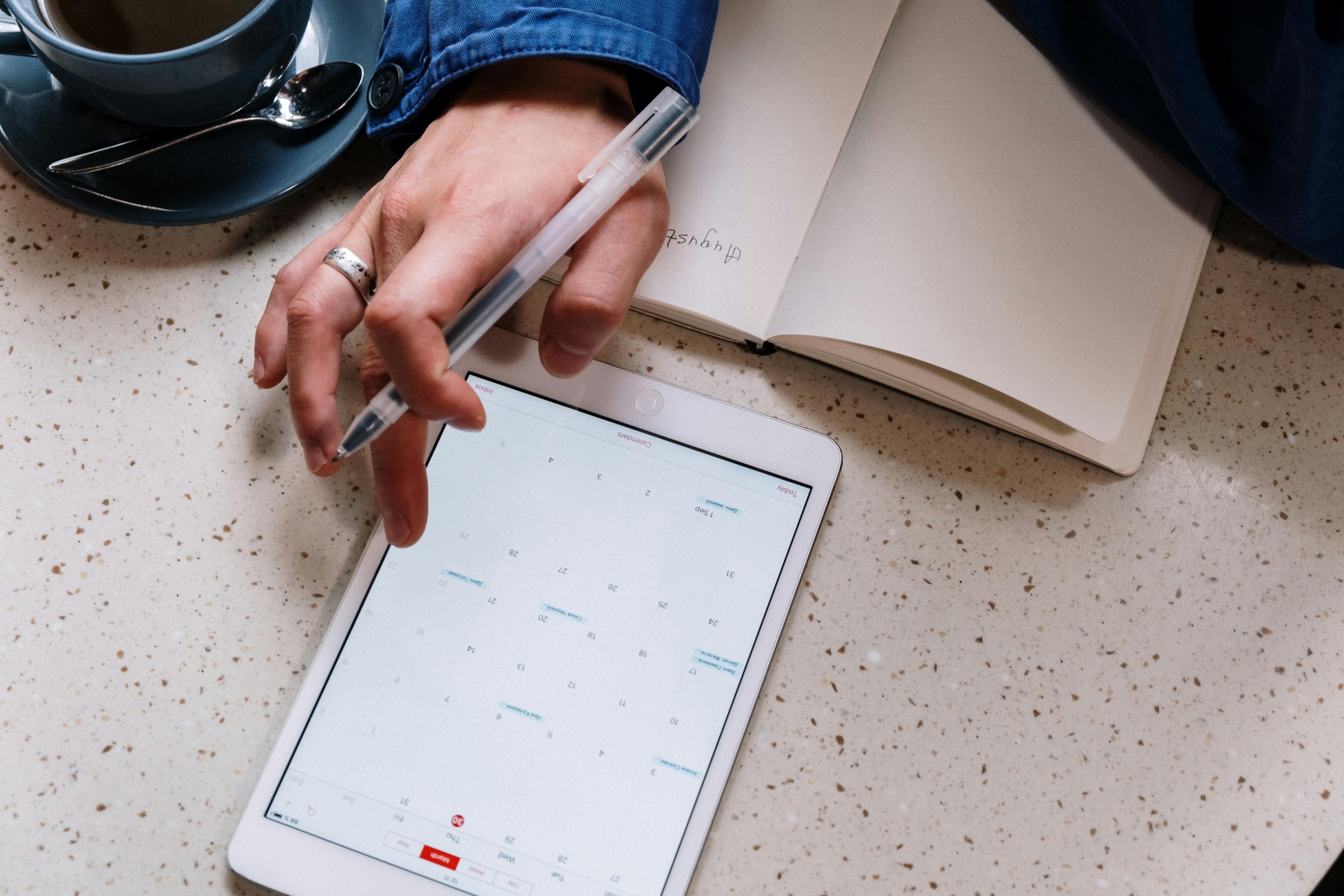 https://www.pexels.com/photo/person-holding-pen-and-using-a-tablet-5053742/