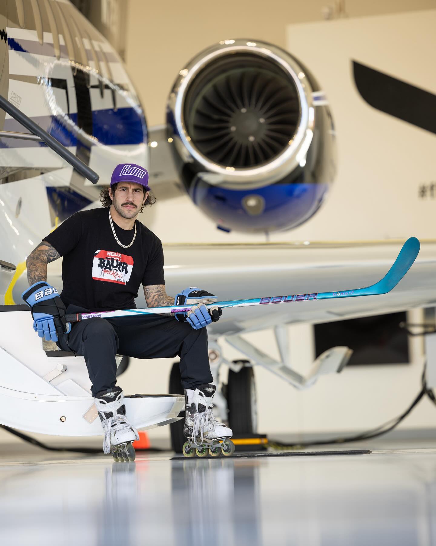 Pete Swaggy P Lenes sitting on a private jet with a Bauer stick and rollerblades