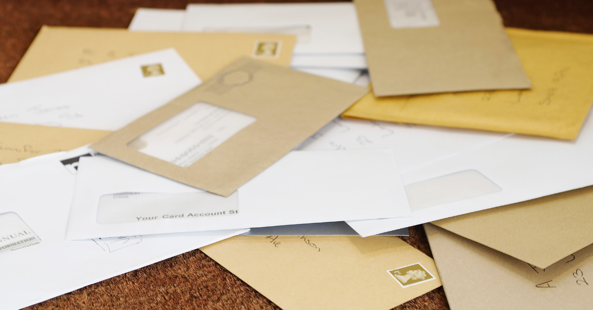 Stack of brown envelopes with credit card statements and bills showing disorganised business finances