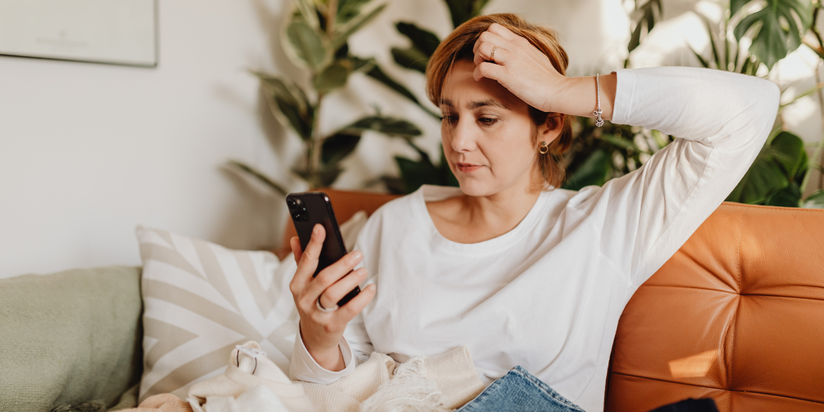 woman over 50 looking at phone alone