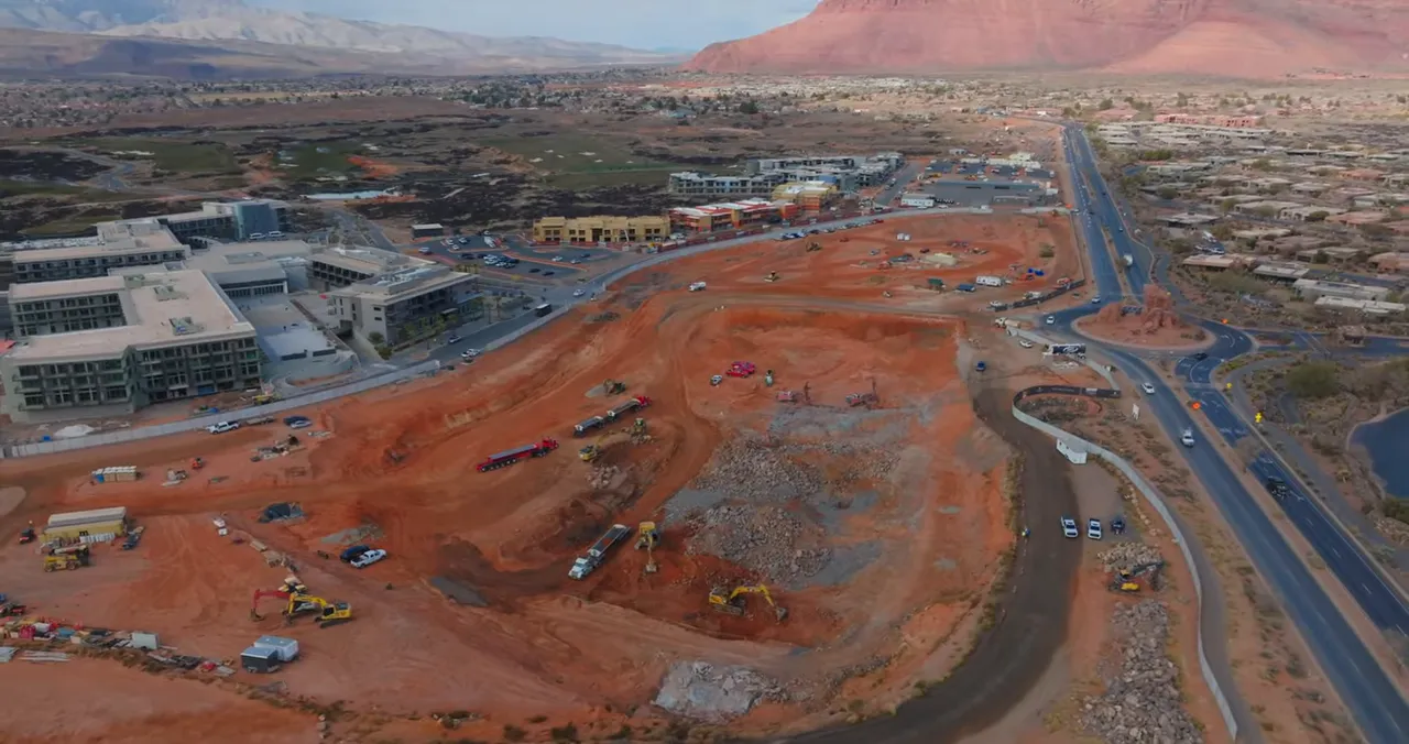 Aerial view of active red dirt construction site with roads and equipment near the resort