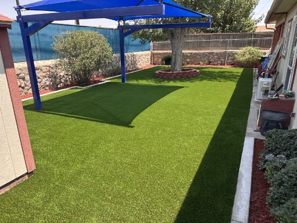 Backyard with shade sails and artificial turf