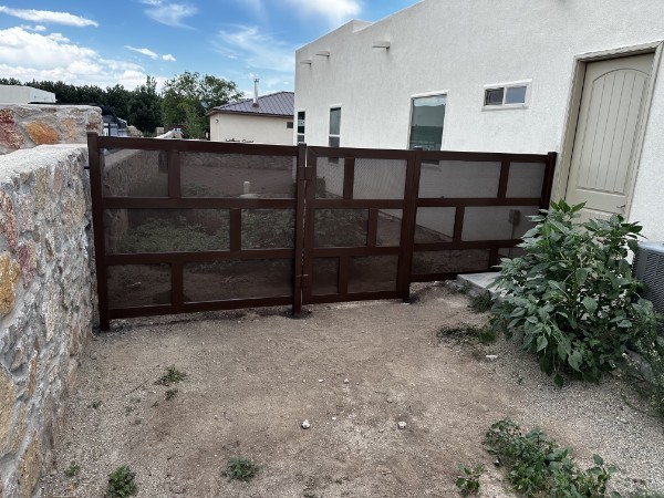 Brown metal privacy gate beside house