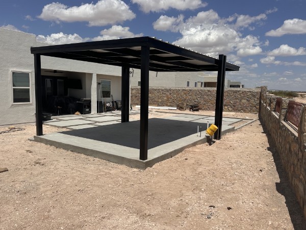 Black metal pergola over concrete patio slab