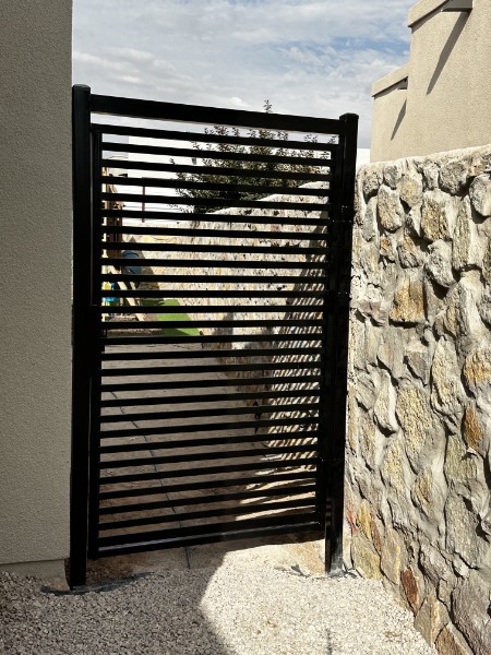 Black Metal Side Gate Next to Rock Wall — The Turf Cleaners El Paso