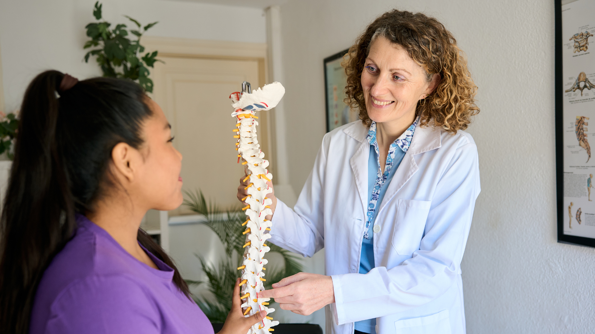 A chiropractor talking with a patient during a consultation