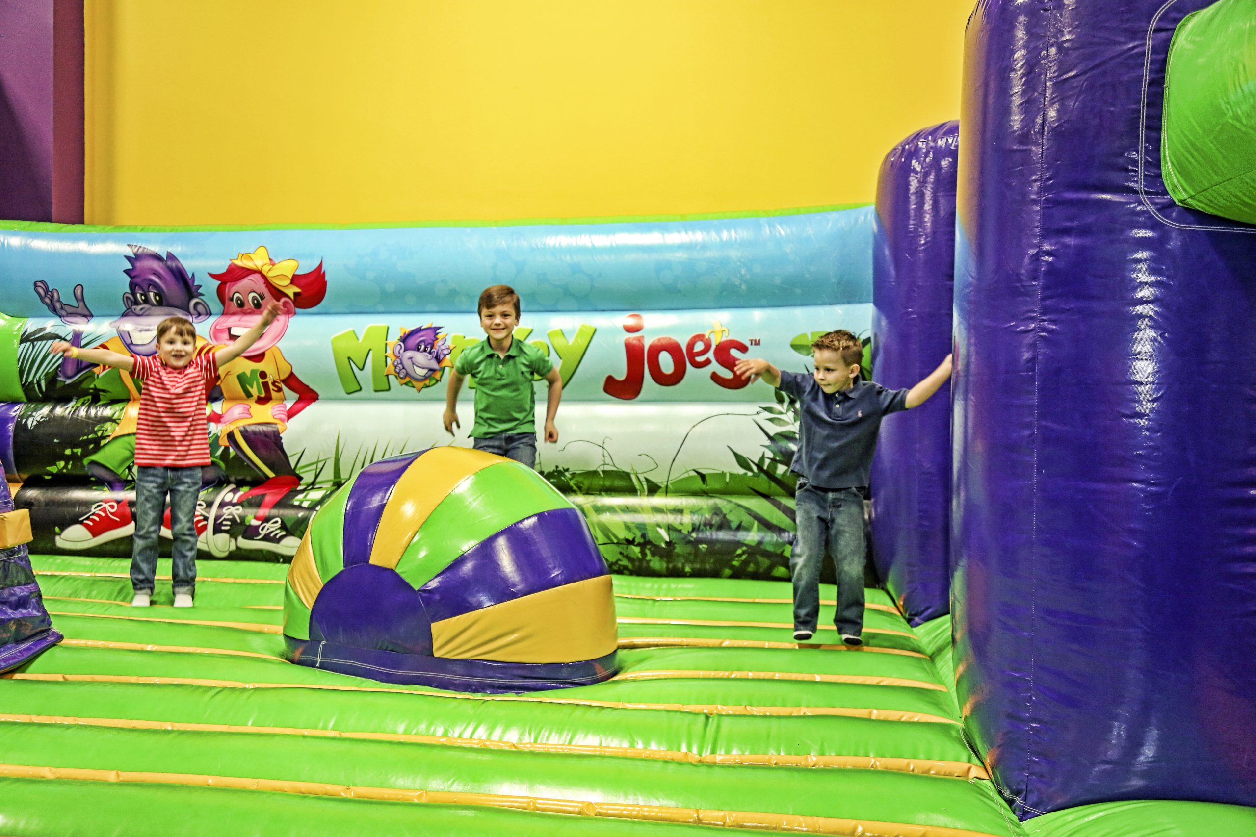 Kids playing on bounce houses at Monkey Joe's