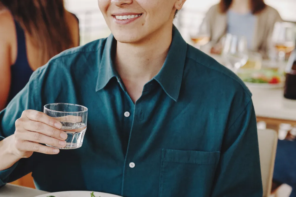 Person mit Wasserglas – Abstinenz im Alltag