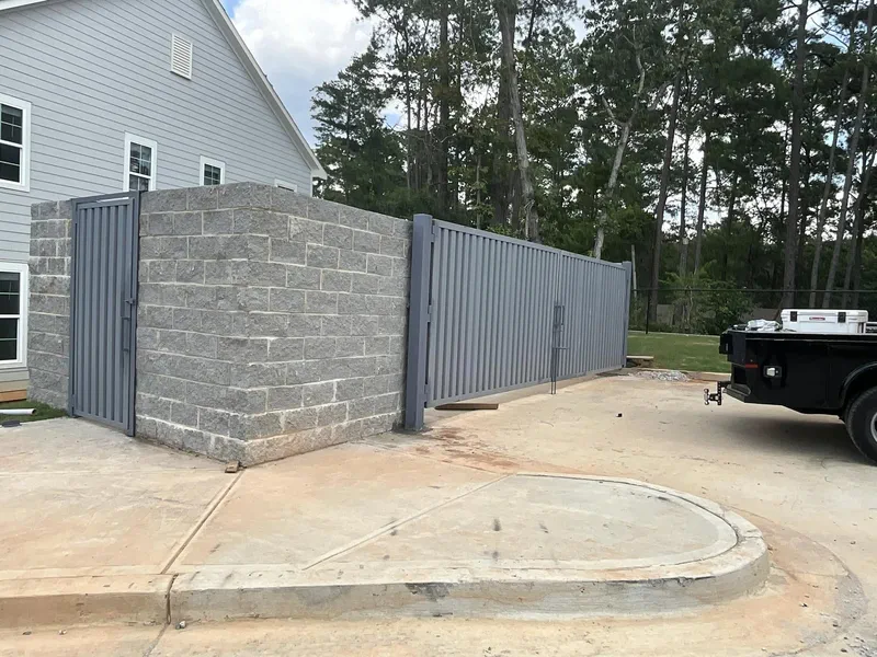 Long metal fence run and gate along a residential street
