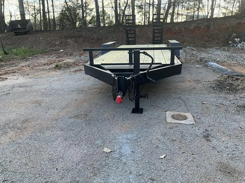 Utility trailer with a timber deck parked on gravel