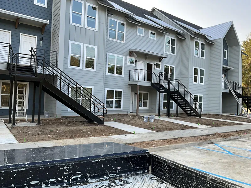 Black steel exterior stairs and landings across a row of townhomes