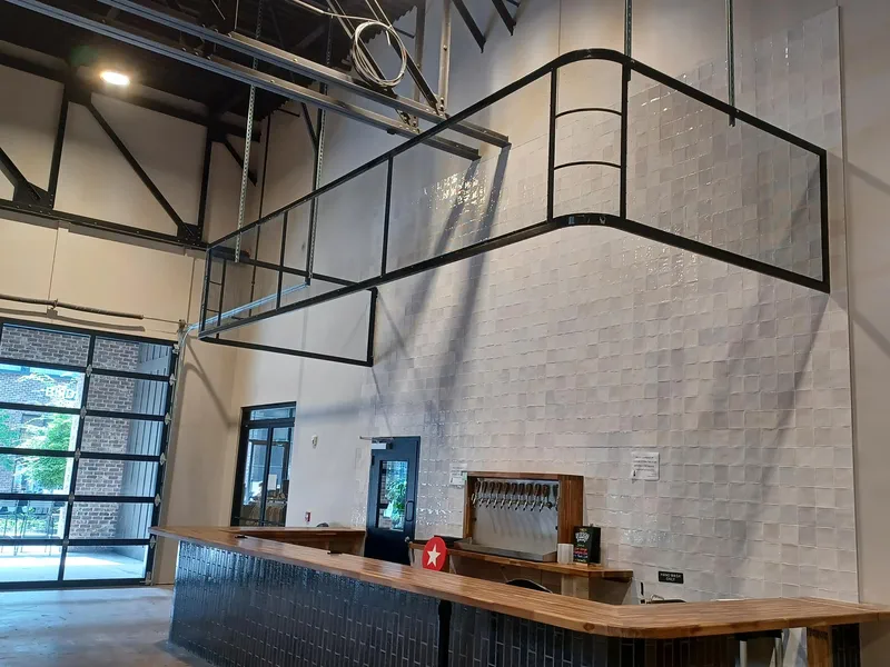 Black steel mezzanine railing above an interior commercial space