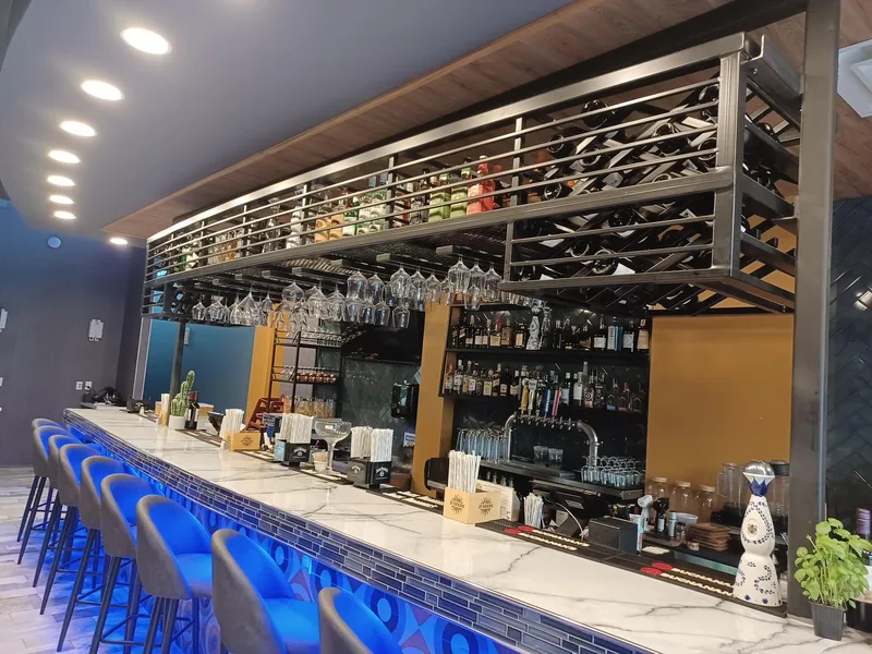 Suspended steel wine-rack framework above a restaurant bar