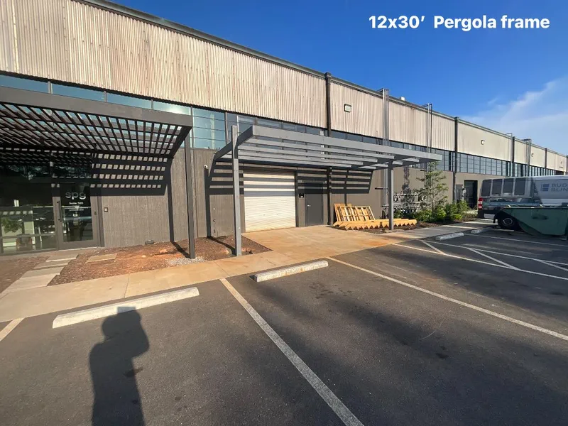 Steel pergola frame running along a commercial building facade