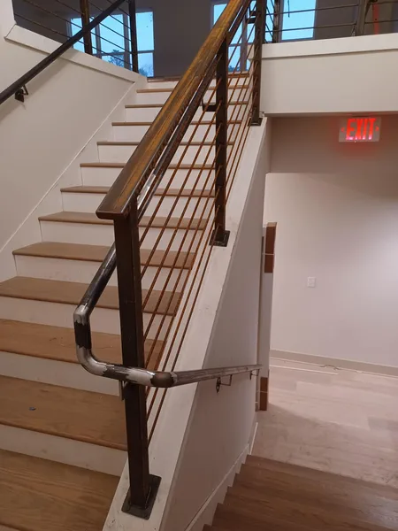 Interior steel stair railing finished with a timber handrail