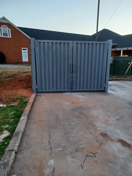 Grey metal double gate closing off a residential driveway