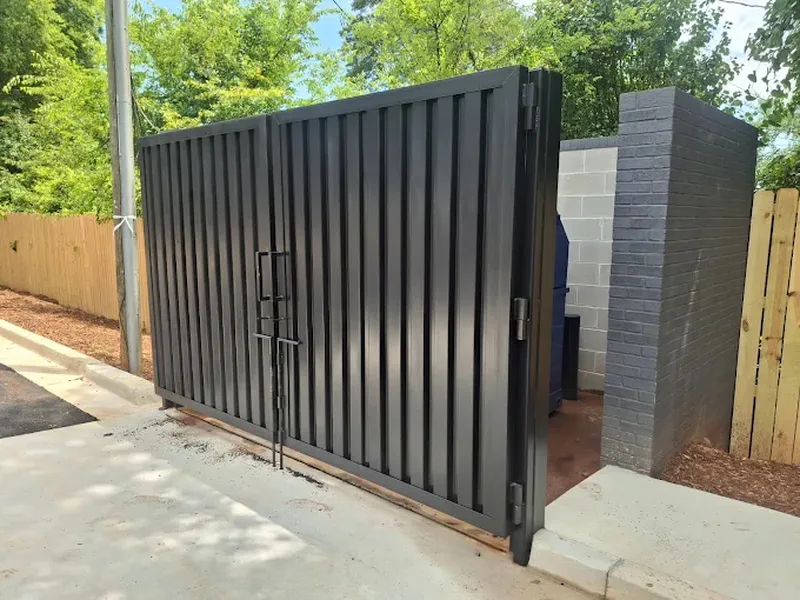 Tall dark metal privacy gate hung between masonry columns