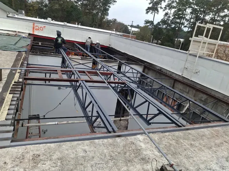 Steel roof framing spanning an open building, seen from above