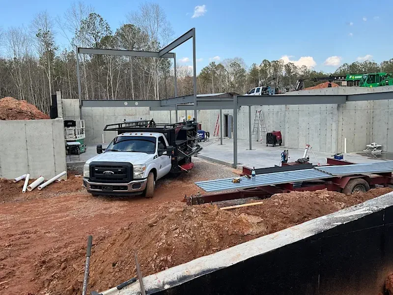 Steel framing and a service truck on a commercial site under construction