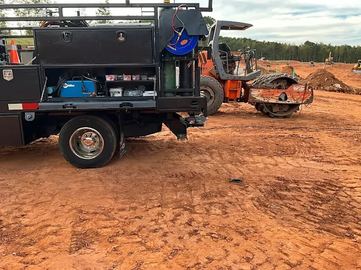Welding service truck with its onboard rig parked on a graded job site