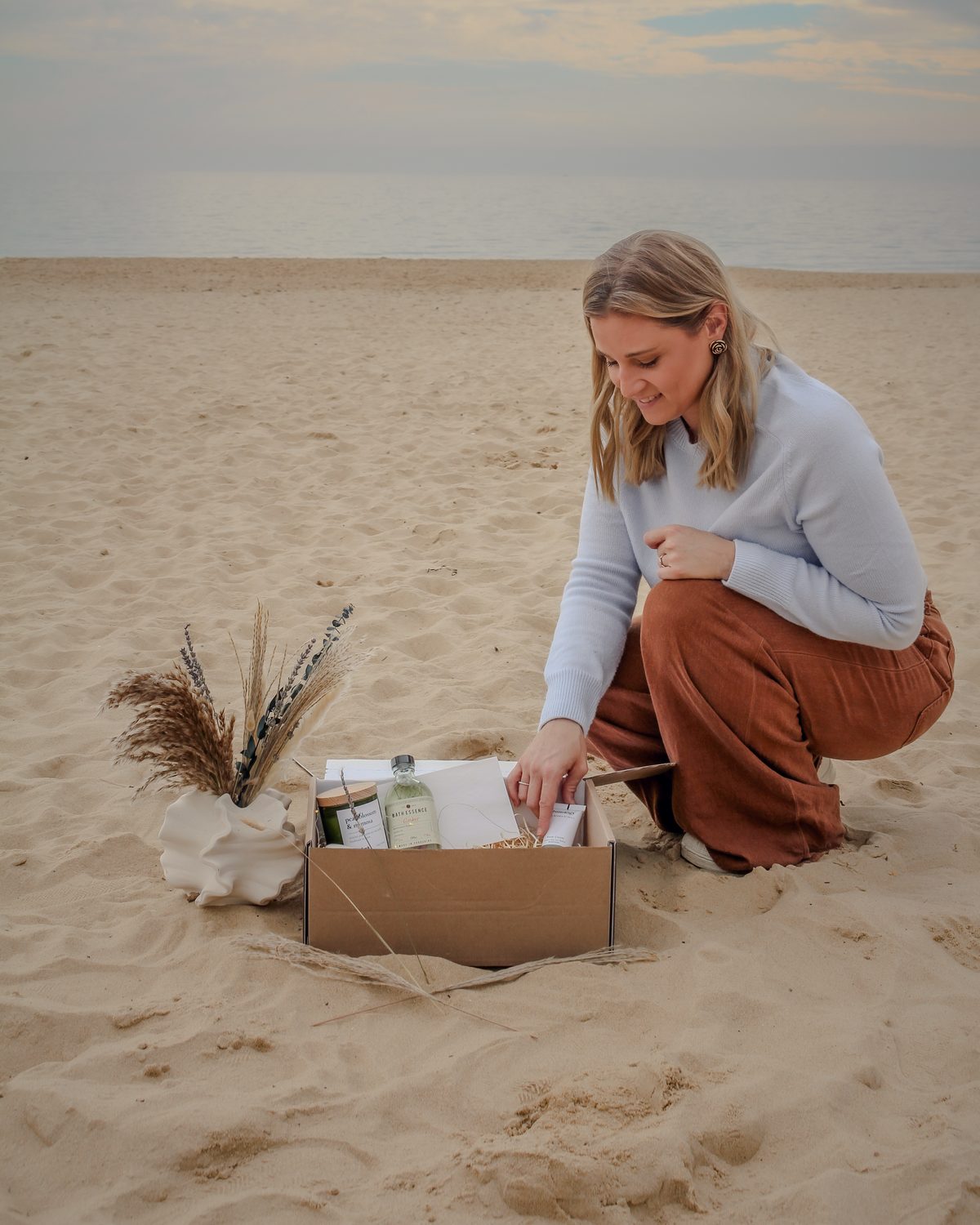 Danni packing a Tide & Wild hamper on the beach