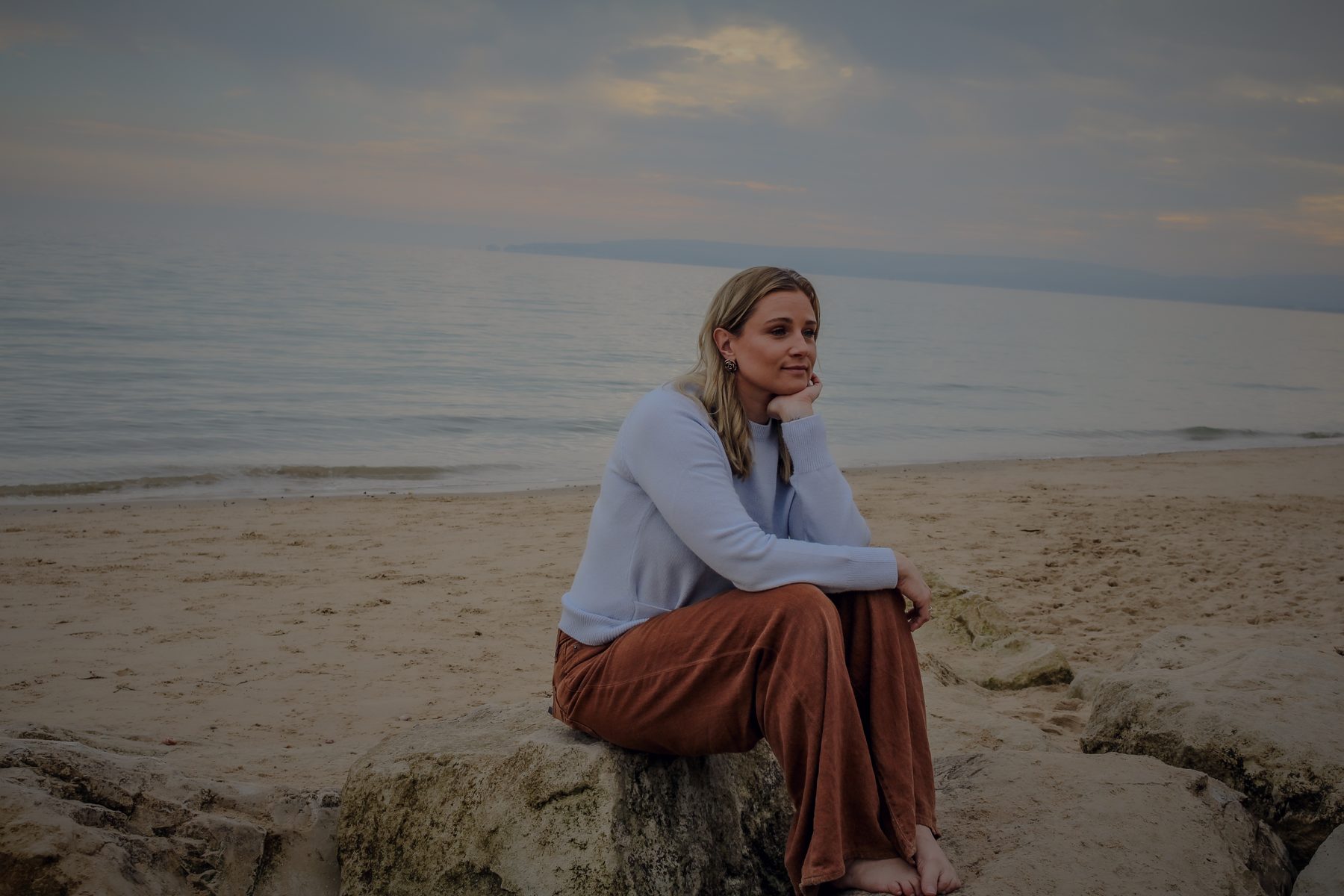 Danni resting on the rocks by the water
