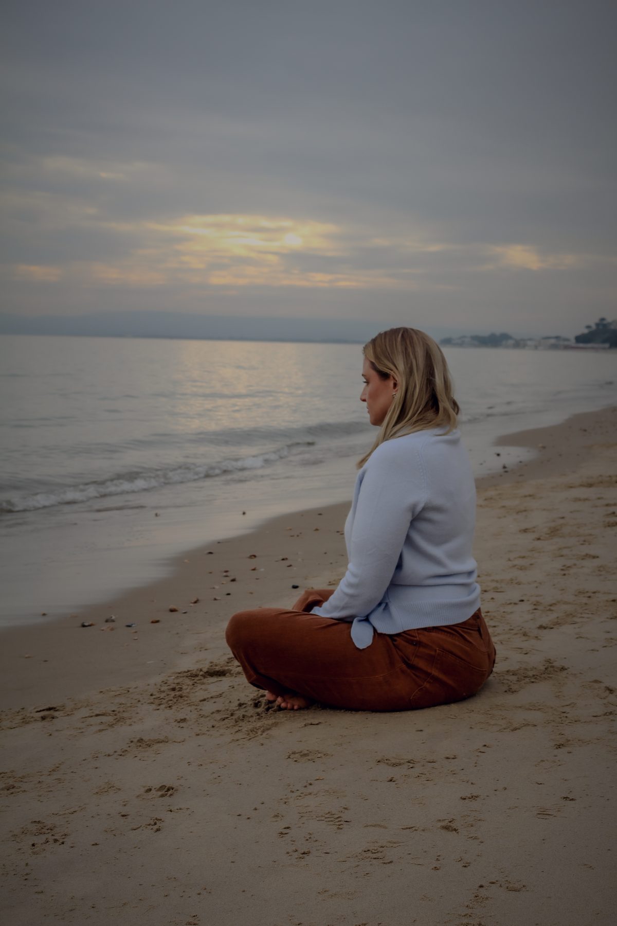 Danni sitting quietly by the sea at dusk