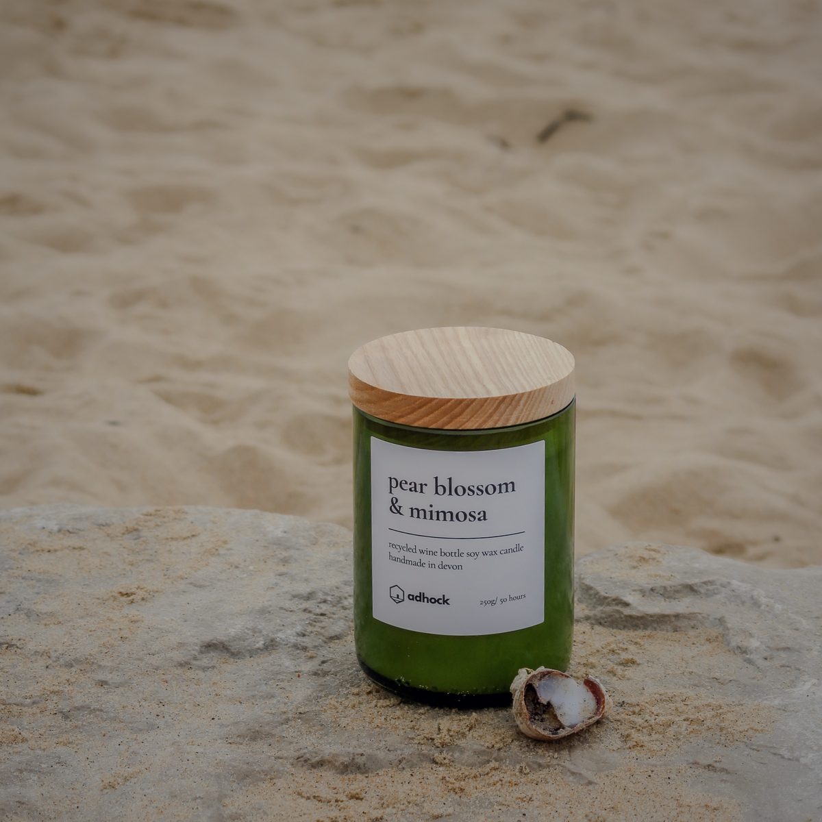 Pear blossom and mimosa candle on a rock