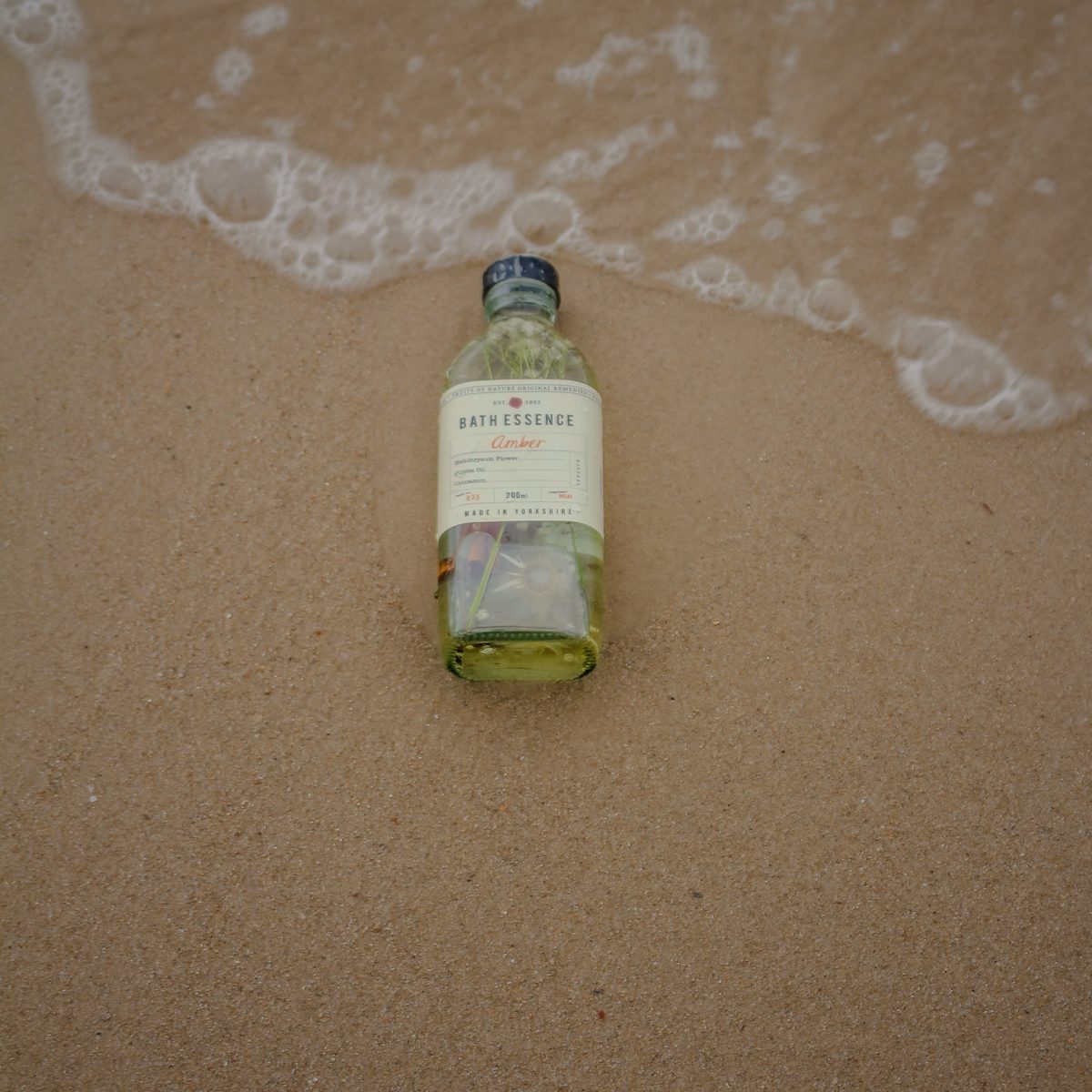 A bottle of bath essence in the shallow surf