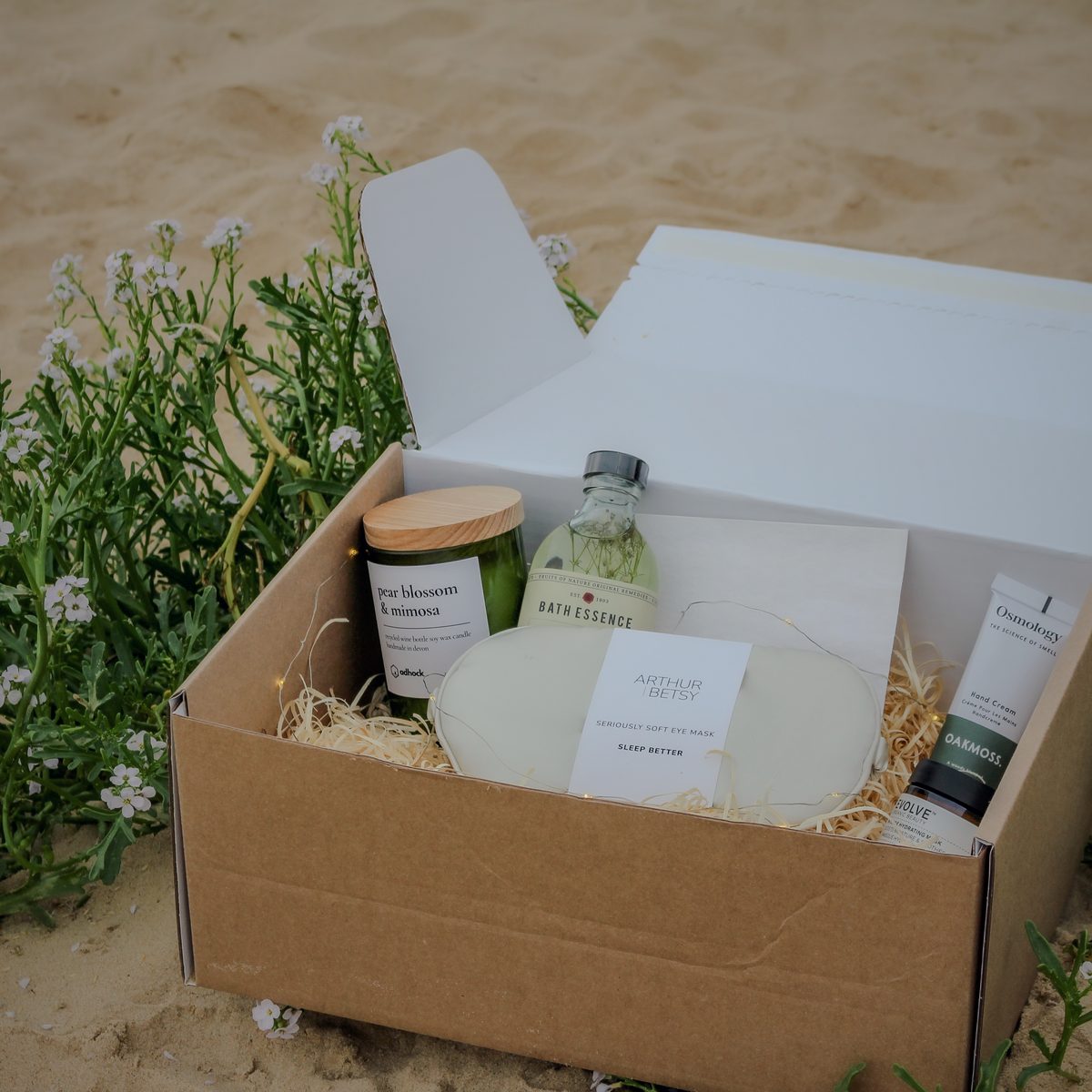 A Tide & Wild hamper among sea kale flowers on the beach