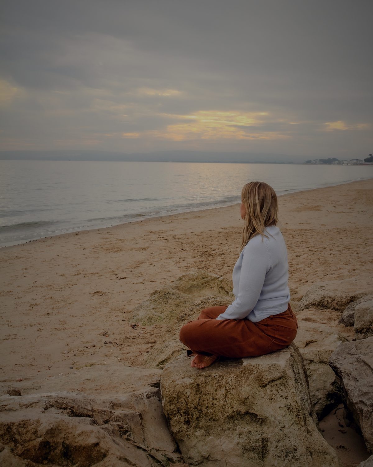 Danni sitting on the rocks looking out to sea