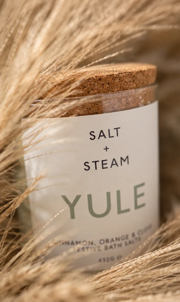 A jar of Yule bath salts nestled in pampas grass