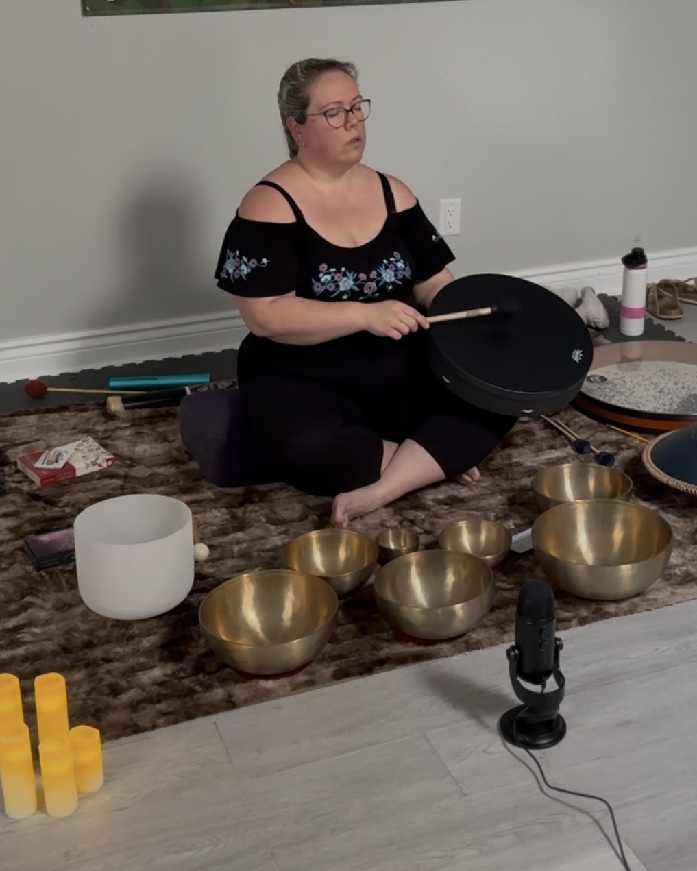 Karolina Autumn playing the Remo hand drum sitting amongst sound healing instruments