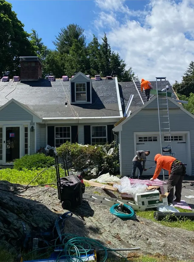 FJM Construction crew tearing off and re-roofing a cape-style home on the North Shore