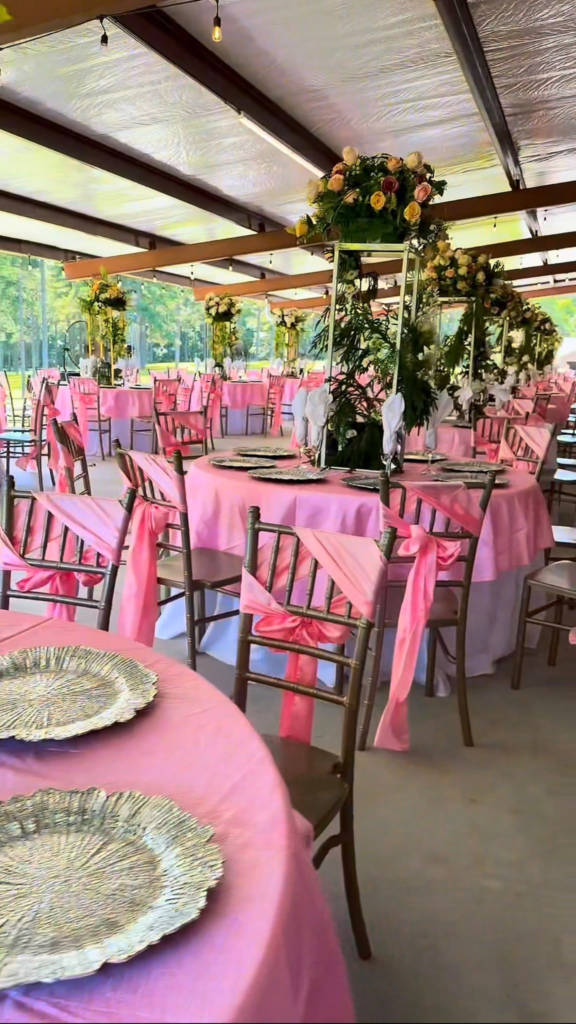 Mesa de celebración al aire libre con globos en tonos pastel y fondo rústico