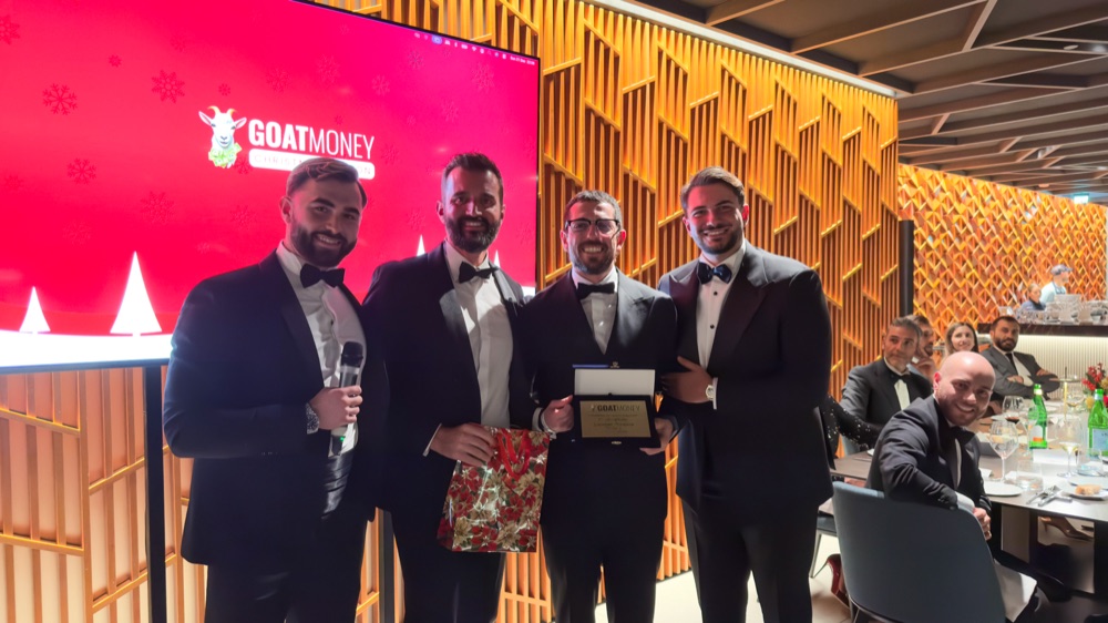 Orso e il team GOAT Money premiano uno studente durante la cena di gala