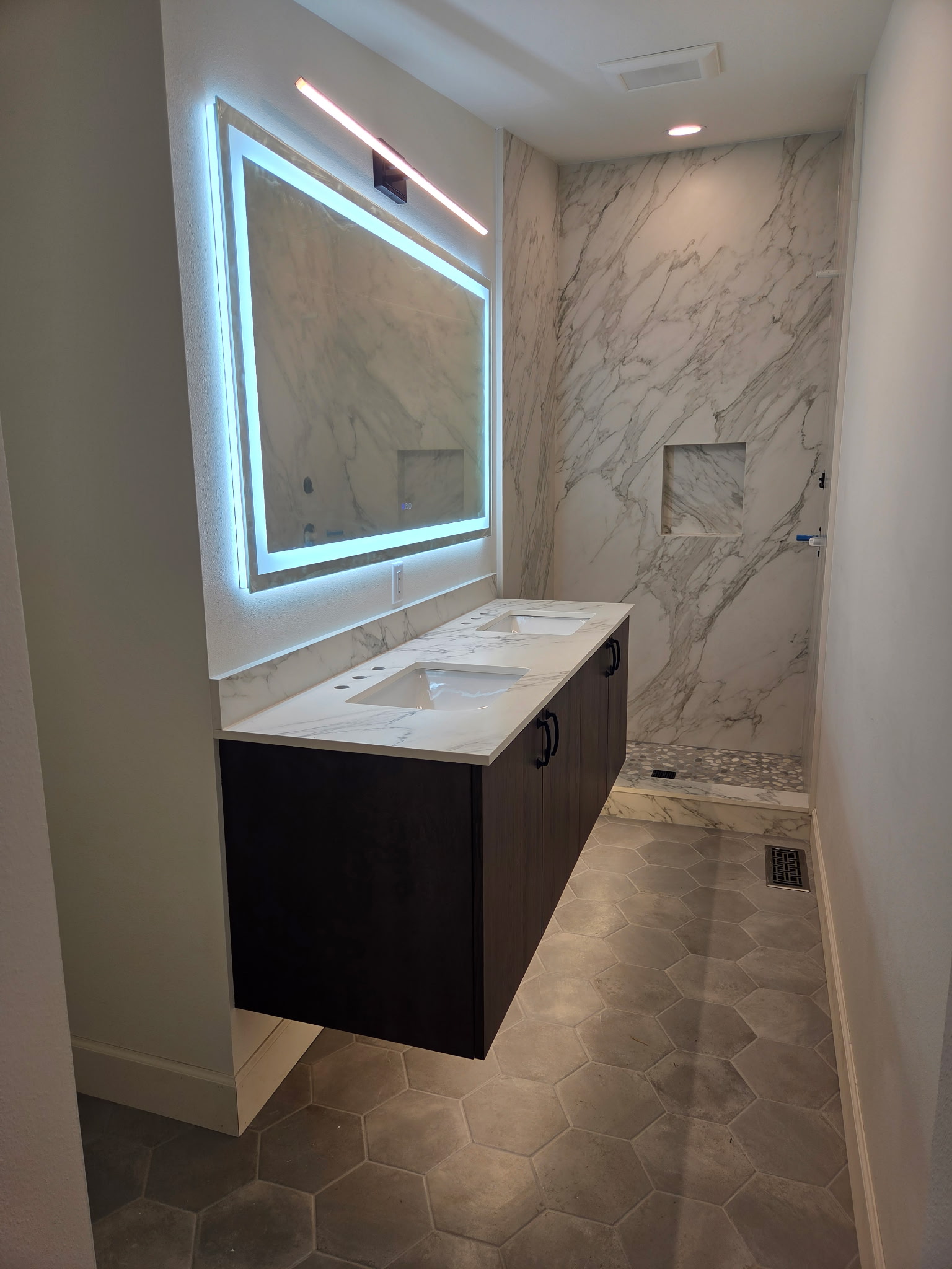 Luxury bathroom remodel with LED mirror and marble shower