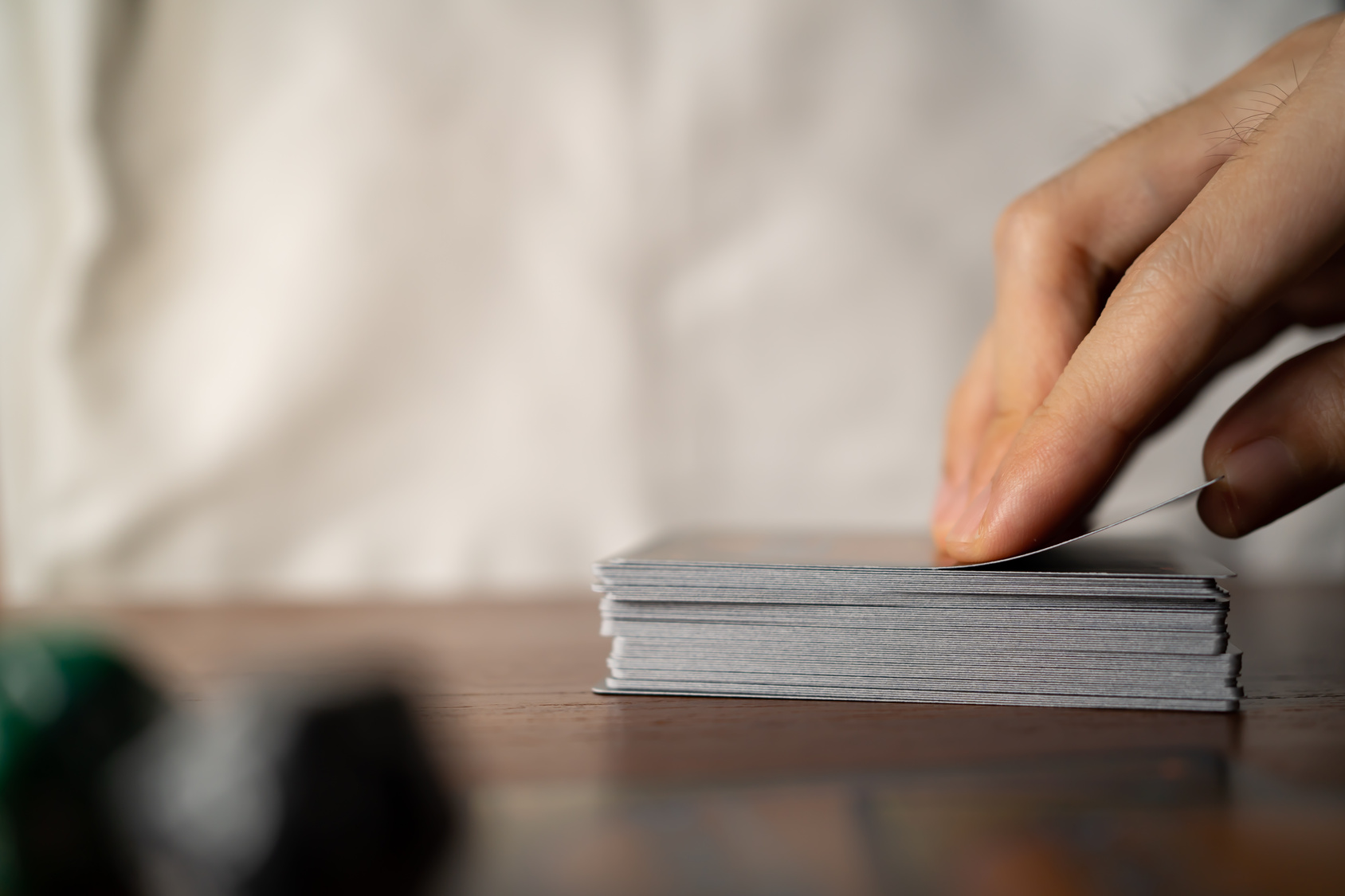 Hands selecting a trading card from a stack.