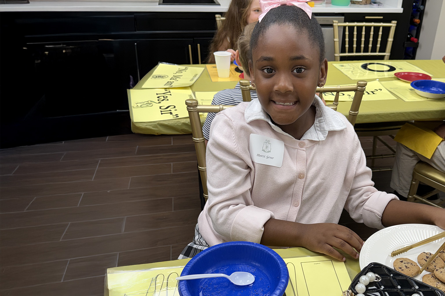 Young lady student learning to pass food items during a meal. Learning table manners at NLJC Pre-cotillion class Brentwood, TN 