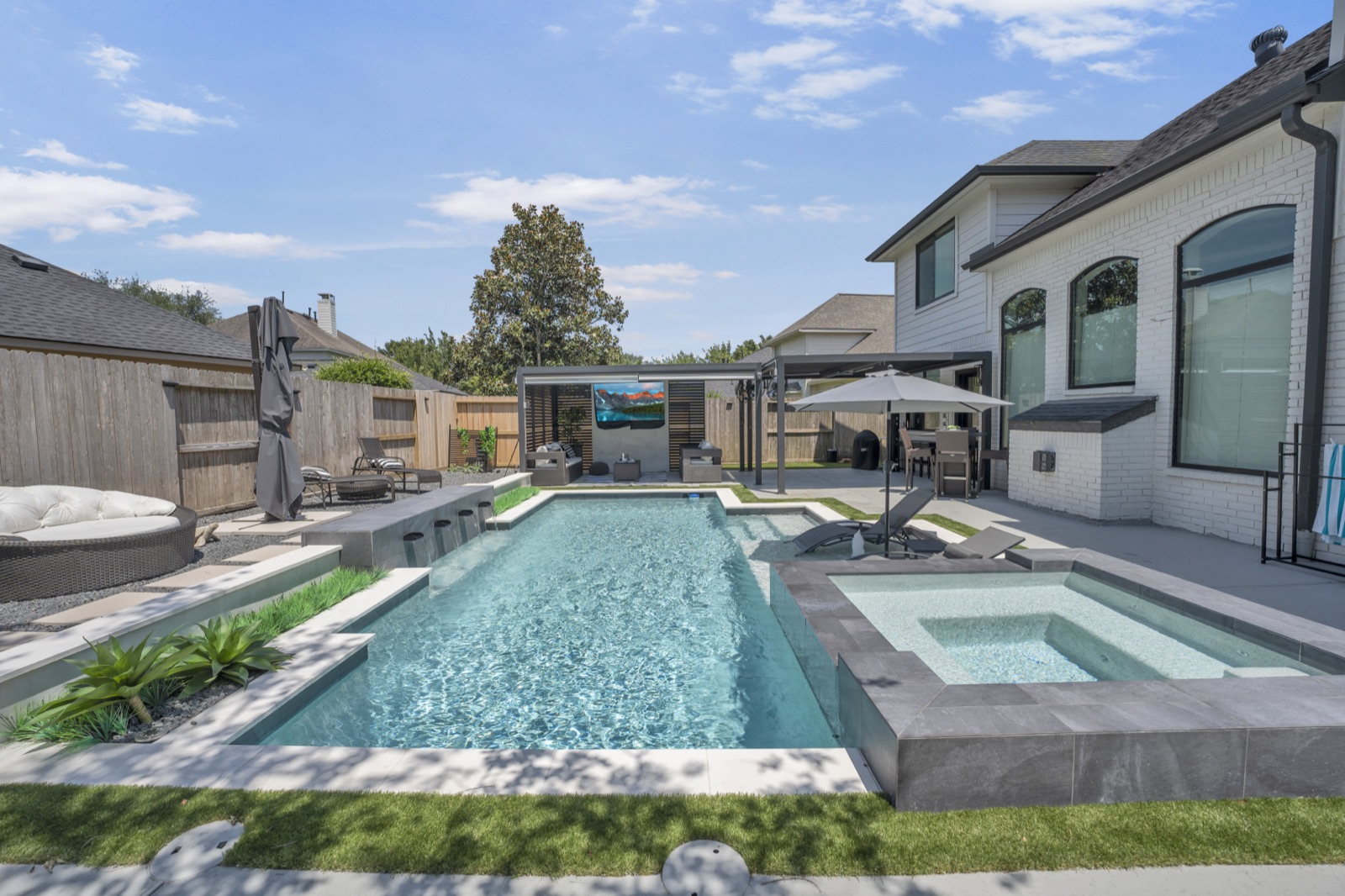 Pool with tanning ledge and spa spillover in Houston