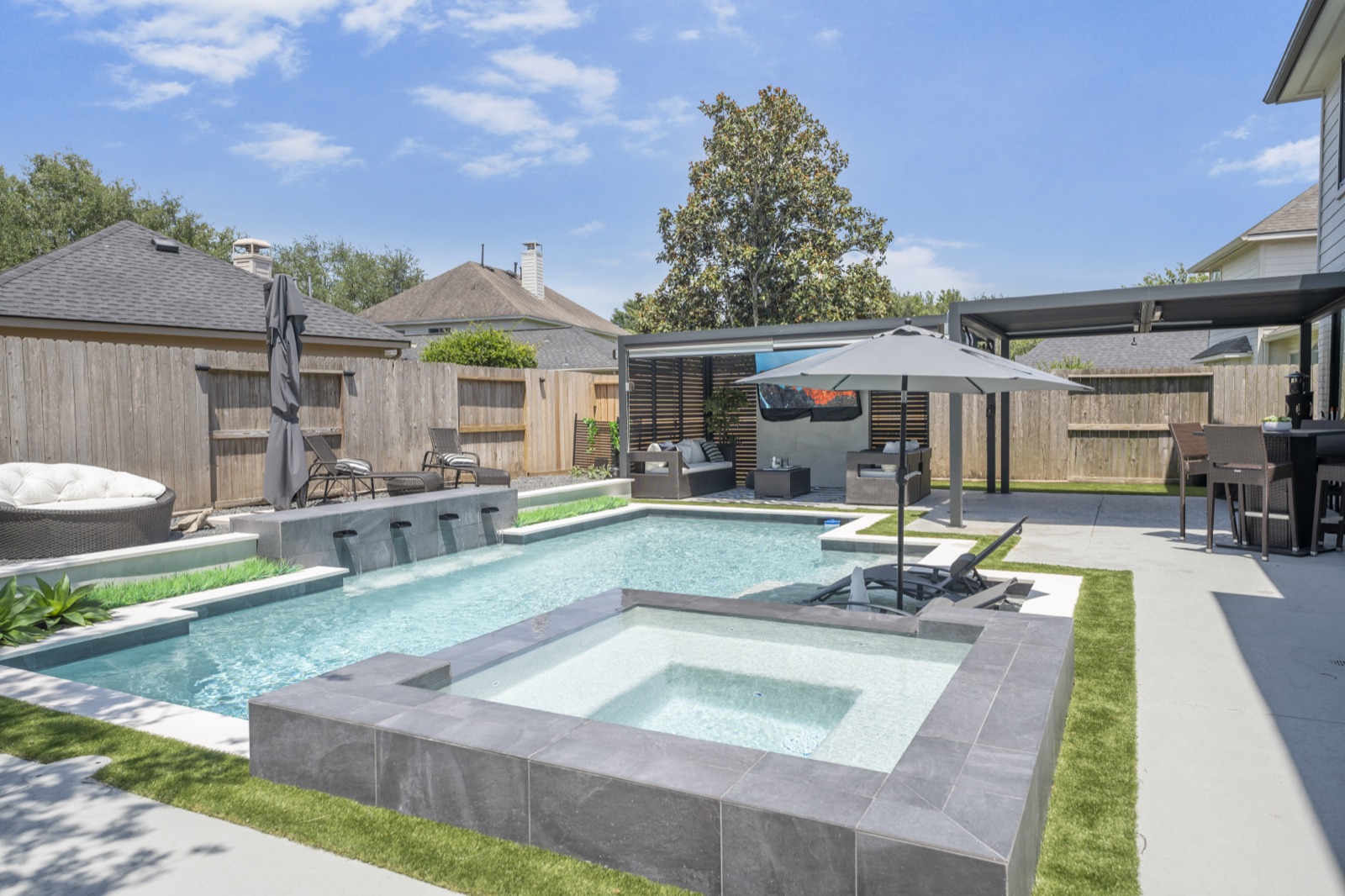 Custom gunite pool with attached spa and tile decking in Houston