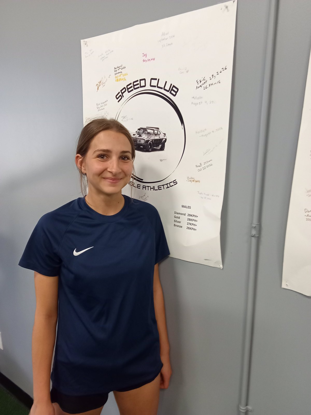 Nina beside the Jungle Athletics Speed Club board after setting her record