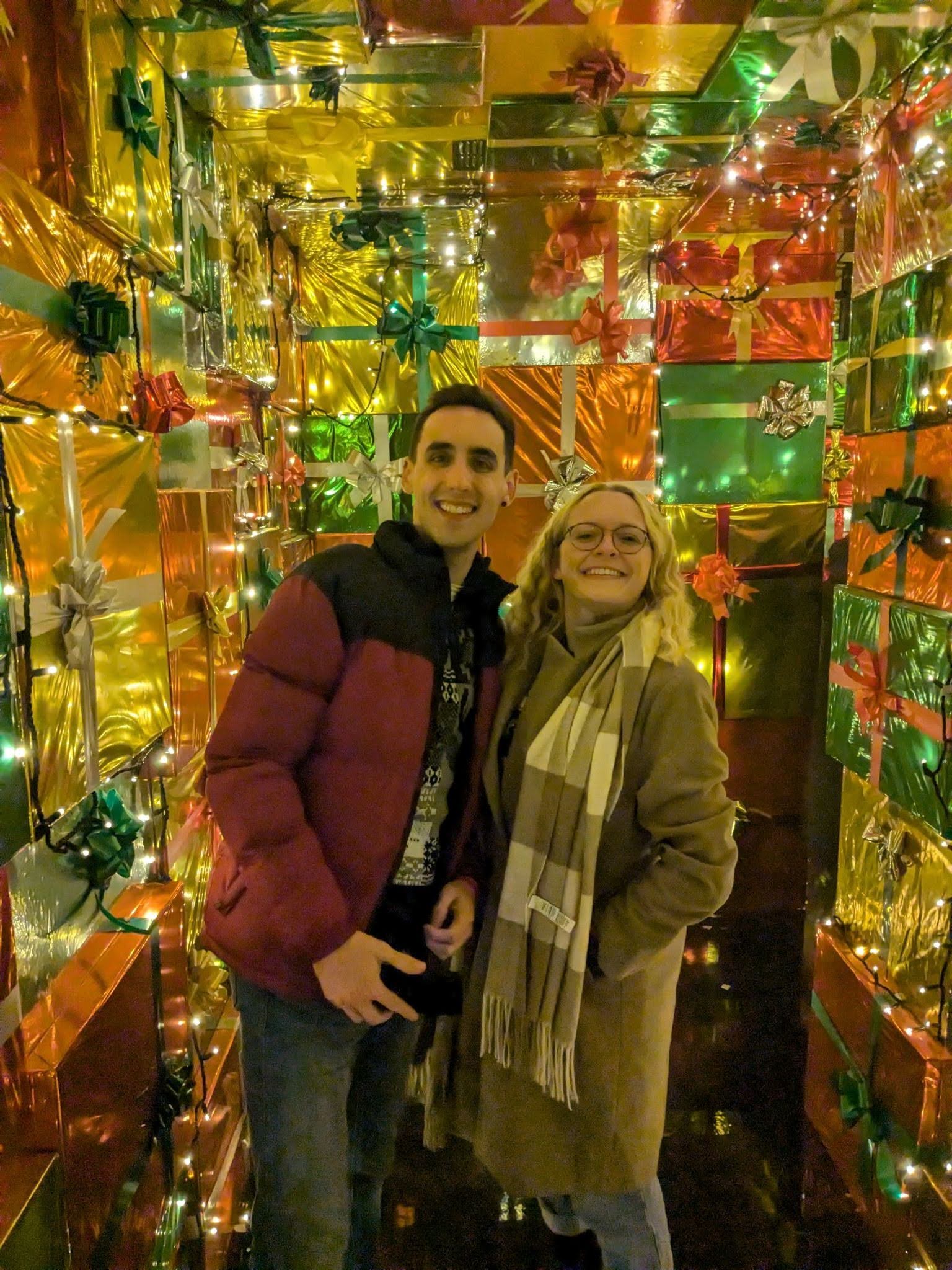 Georgia and KJ in a room of wrapped presents