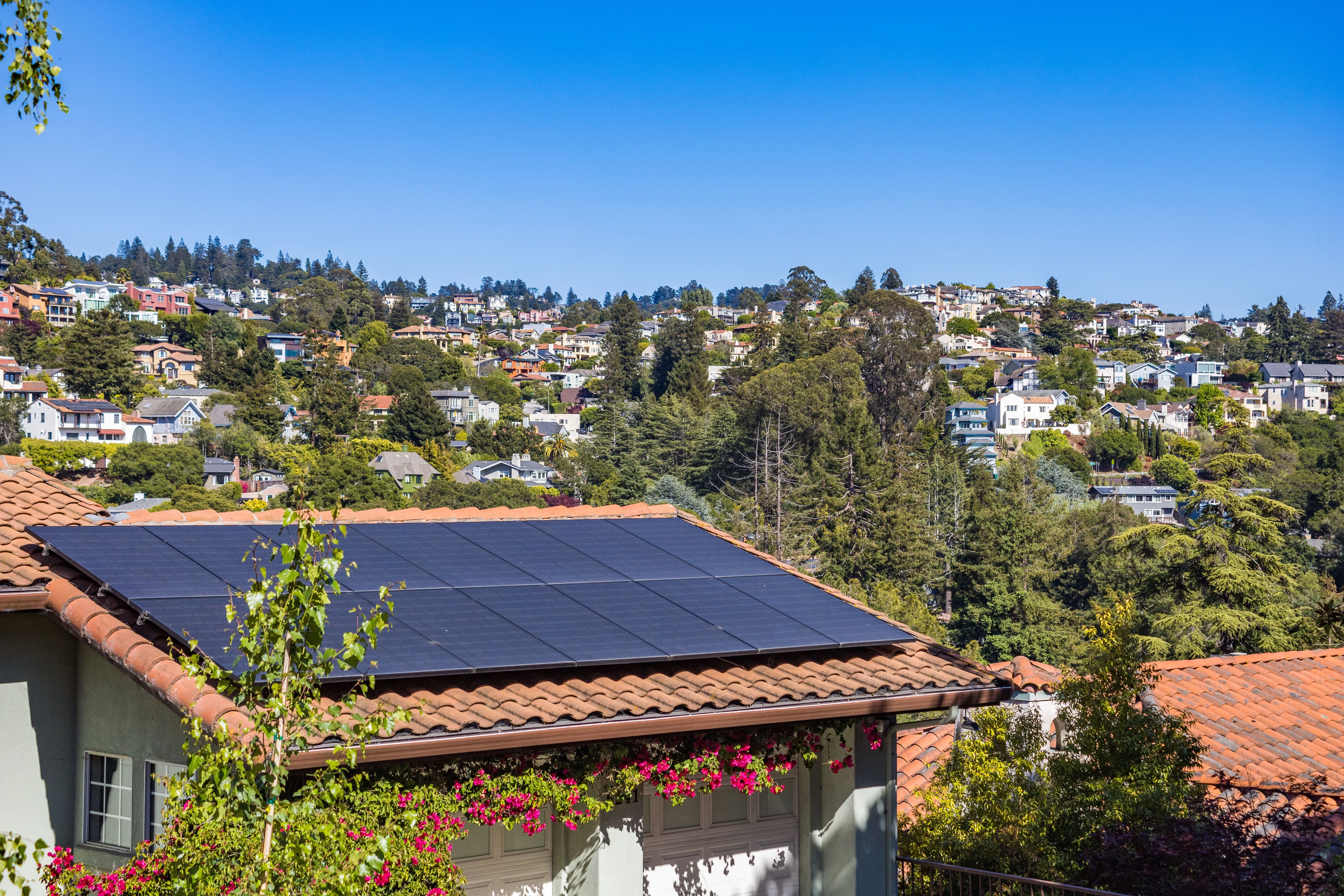 Hillside neighborhood with solar panels on a home rooftop